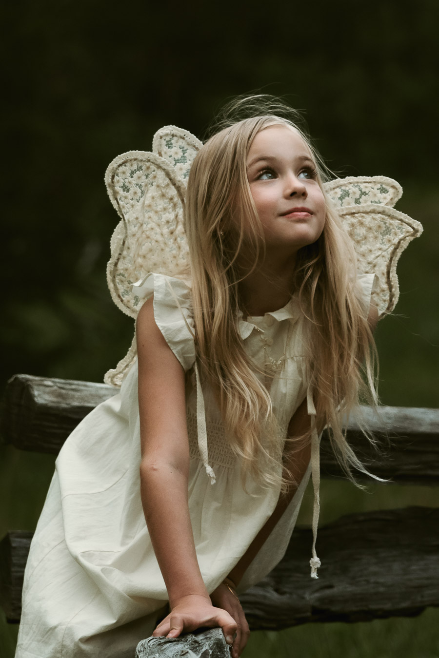 Fine art children's portrait of girl with fairy wings dancing in a sunlit field, by Tammy Jaquith Photography